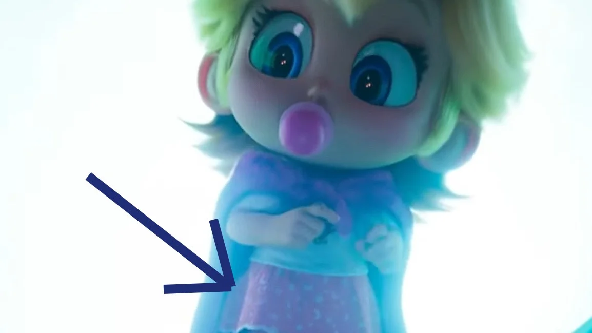 Baby Peach llegando al Reino Champiñón en la película de Super Mario Bros. Un flecha azul apunta a su falda, que tiene lunas y estrellas