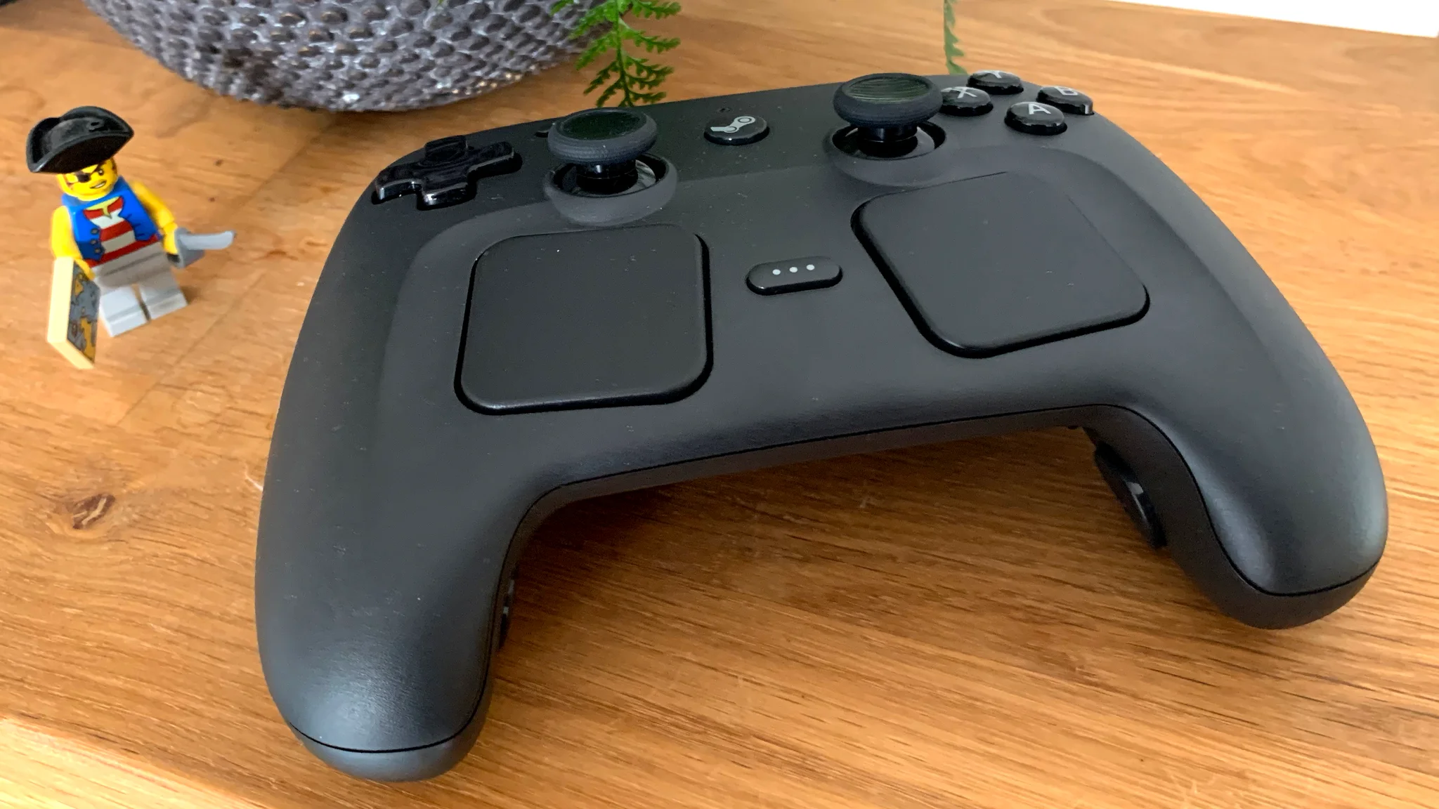 Una foto del nuevo Steam Controller de Valve junto a un helecho y un temible pirata de Lego
